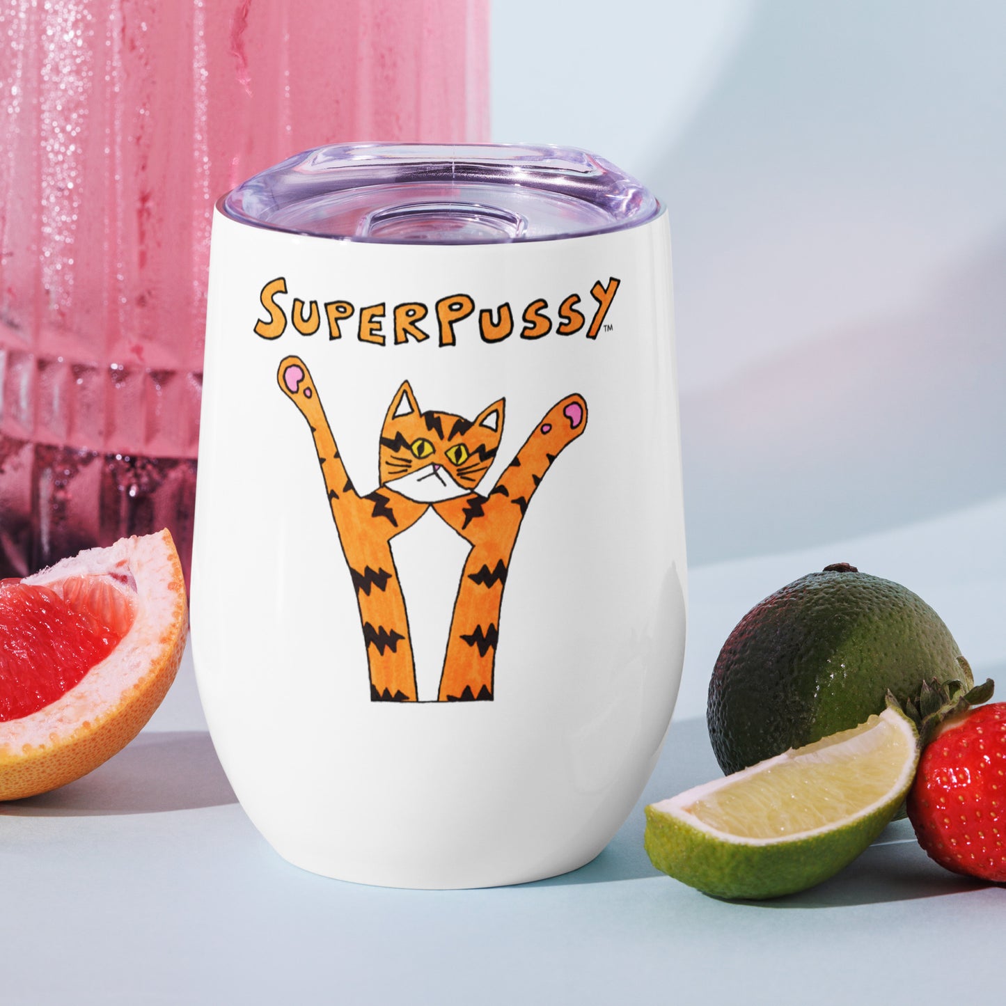 A top view that shows the travel lid on A stainless steel wine tumbler, white, with a drawing of an orange cat with tiger stripes and his paws in the air. "Superpussy" is written in orange above it. Shown with cut fruit beside it.